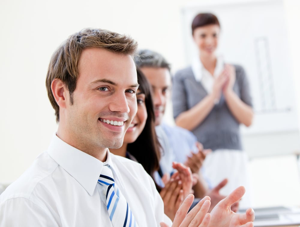 Smling business people applauding a good presentation in the office